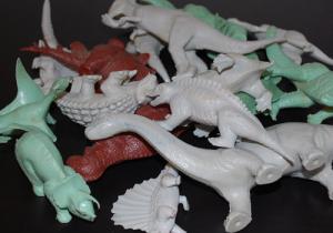 A pile of plastic toy dinosaurs.