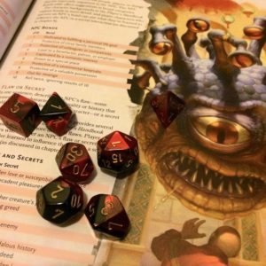 Swirling red and black dice sit on one of the Dungeon Master Guide's many random tables. A beholder stares menacingly at a terrified adventurer.