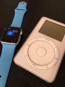 An Apple Watch next to an original iPod (rev 2)