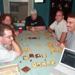 Gamers gathered around a table playing a fantasy card game.