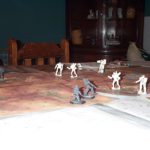 Grey and white robot-like figurines battle on a hexagonal map.