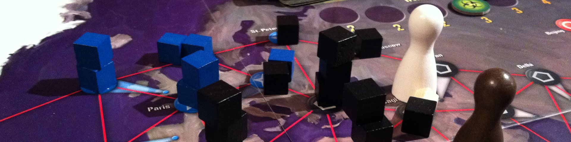 Black and blue cubes -- representing viruses -- are stacked on a map-like game board depicting various cities. A white pawn represents the player character fighting the viruses.