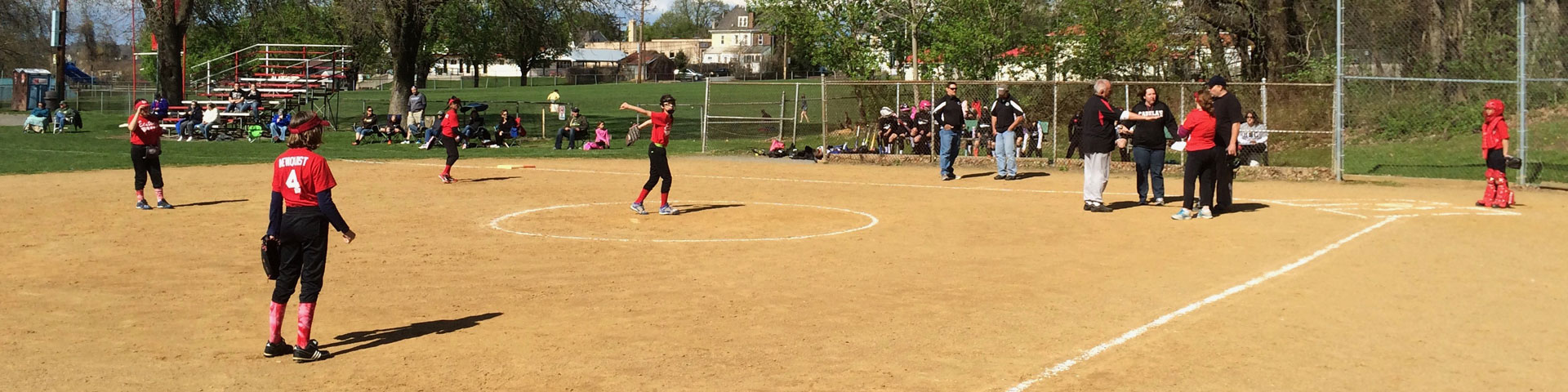 Girls get ready to field the ball during a softball game.