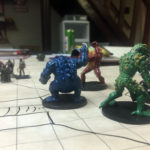Large, frog-like figurines representing different colored slaadi monsters threaten player character miniatures.