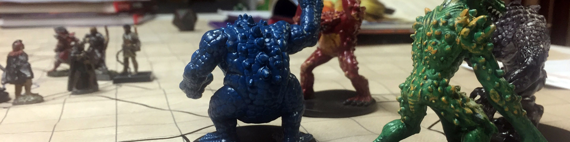 Plastic miniatures of the frog-like monsters known as slaadi stand on a battlemap. In the background can be seen several figures representing player characters.