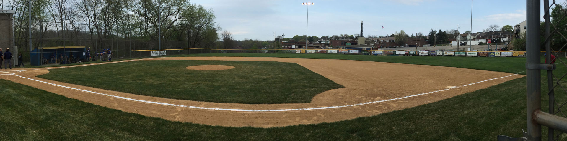 A baseball field in early spring. The field is green, but little else is.