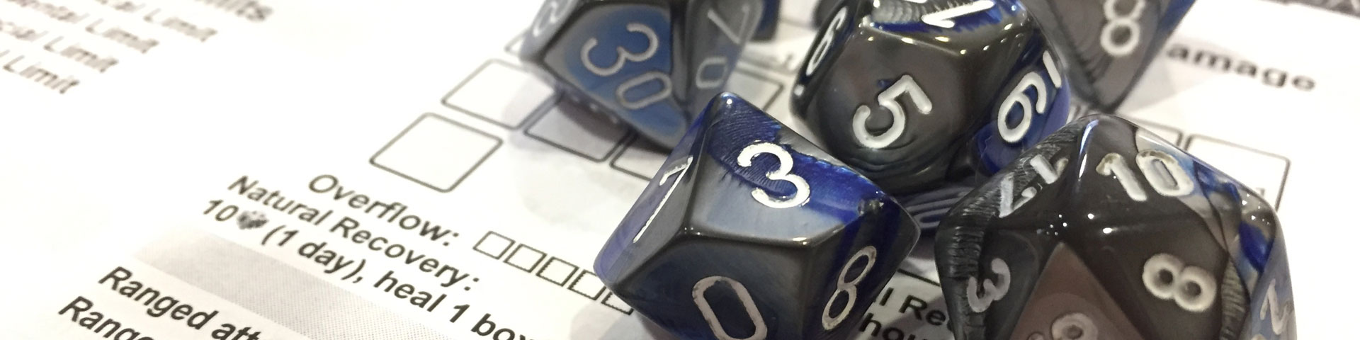 A close-up shot of blue-grey polyhedral dice on a Shadowrun character sheet.