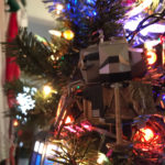 The Apollo-era Lunar Lander nestled among Christmas lights on an evergreen tree.