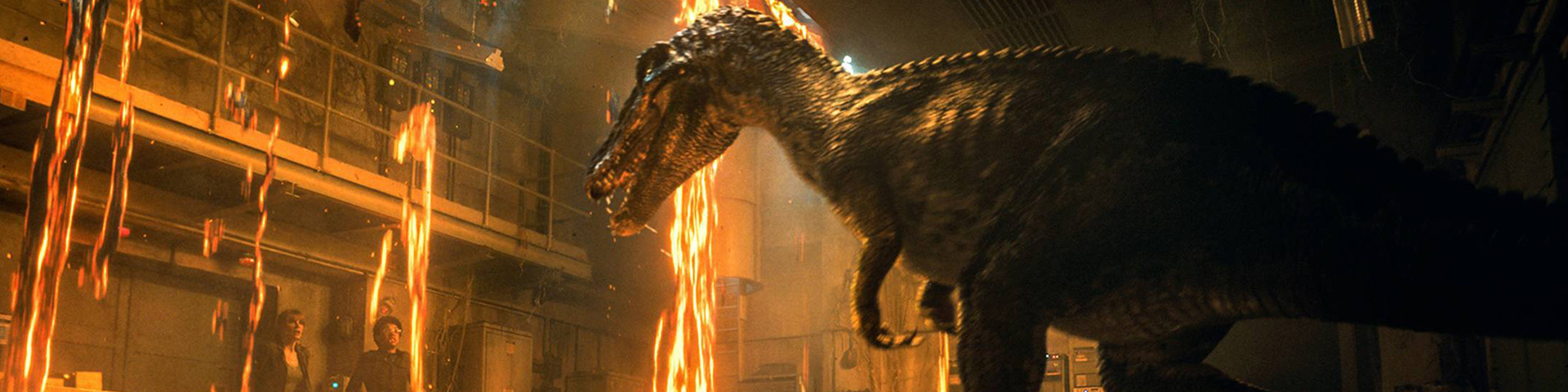 A bipedal dinosaur appears in a burning building, threatening a man and a woman who appear off to the left.