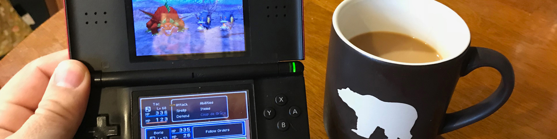 Dragon Quest IX appears on the screen of a Nintendo DS. Nearby is a mug filled with coffee.