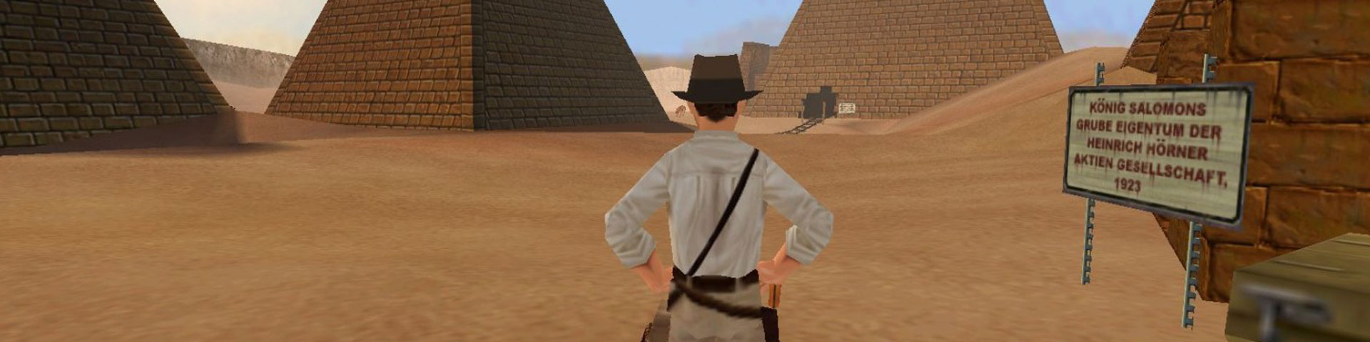 A digital rendering of indiana jones stands with his back to the viewer, surveying some pyramids in the desert.