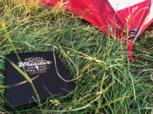 A Kindle in the grass next to a tent.