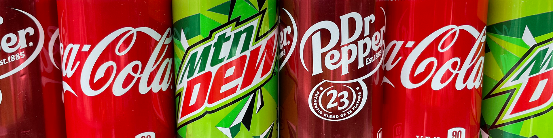A line of soda cans (Dr. Pepper, Coca-Cola, Mountain Dew)