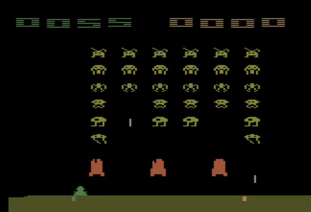 A screen shot of yellow-green 8-bit aliens on a black background descending toward the green player icon at the bottom of the screen. Orange shields stand between the invaders and the player. 
